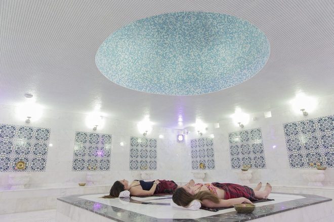 Couples lying on the heated marble platform in the hammam room at Old Hammam & Spa